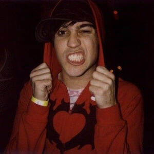 pete wentz in a red clandestine hoodie, making a growling face